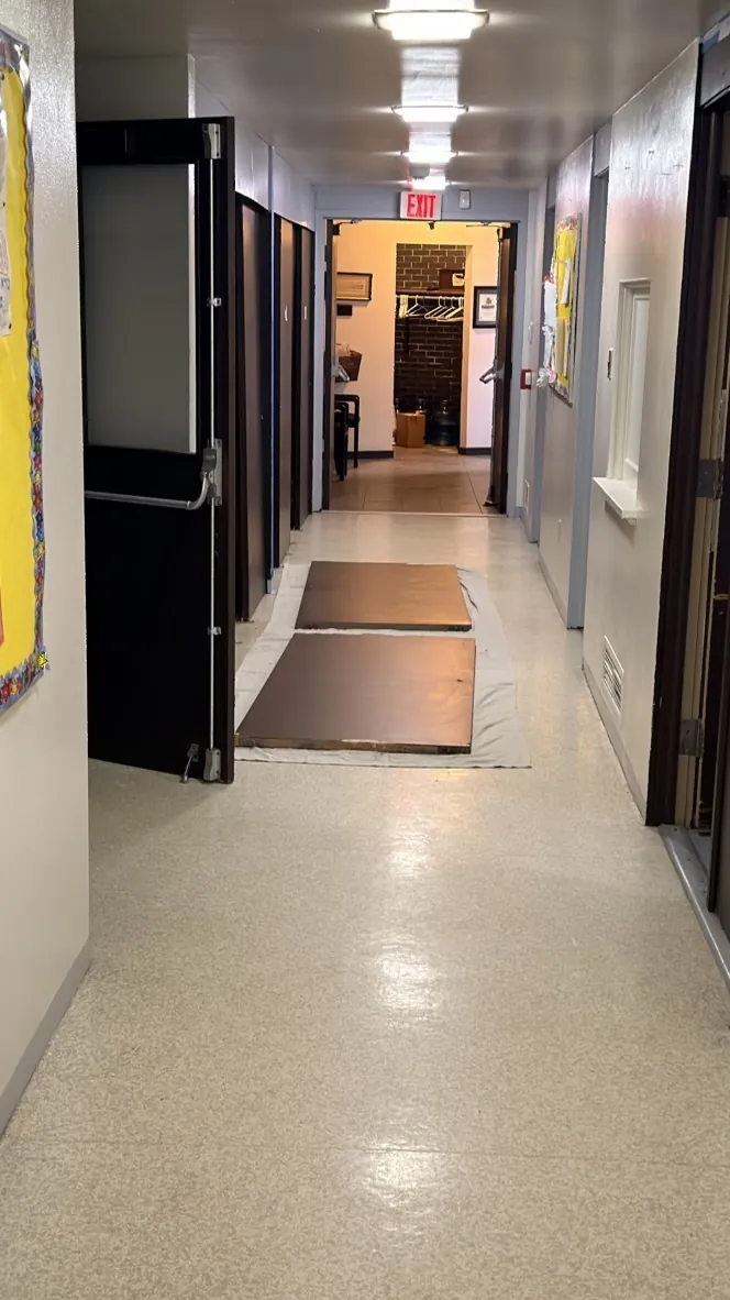 A corridor with hardboard floor protection laid over the finished floor during work