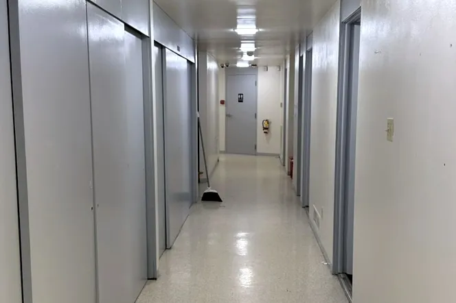 A cleaned office corridor with a polished floor reflecting the ceiling lights